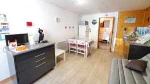 A compact living space with a kitchenette, a dining area, and a sofa.