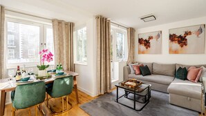 Ein modernes Wohnzimmer mit Essbereich, einer Couch und Kunstwerken an den Wänden.