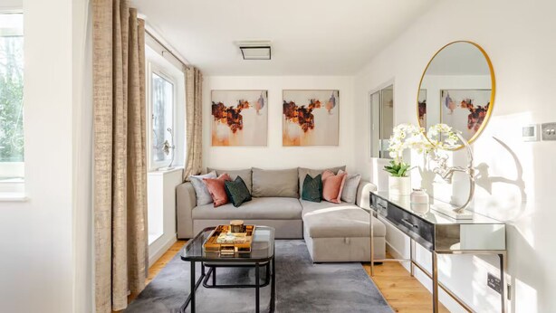 Ein modernes Wohnzimmer mit Sofa, Couchtisch und Kunstwerk an der Wand.