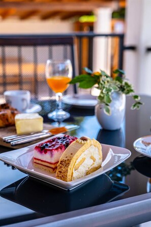 Ein Tisch mit einer Dessertplatte, einem Glas Orangensaft und einer Wasserkaraffe.