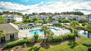 A resort with multiple-story buildings, a central swimming pool, and a small water feature. - Willow Bend Condo | Close to Barefoot Golf Courses (North Myrtle Beach)