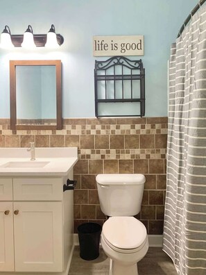 A bathroom with a white sink, a mirror, a toilet, and a shower curtain. - Willow Bend Condo | Close to Barefoot Golf Courses (North Myrtle Beach)