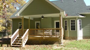 A two-story house with a covered porch, a staircase, and a front door.