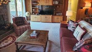 A cozy living room with wooden paneling, a fireplace, a television, and comfortable seating. - Mountain View Chalet in Boone -10 min. to ASU & Downtown; Pet-Friendly (Boone)
