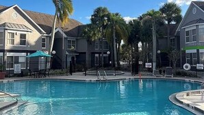 Una piscina rodeada de edificios bajo un cielo azul despejado.