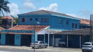 A two-story building with a blue facade and a red-tiled roof. - Pousada Tia Carmem (Ilha Comprida)