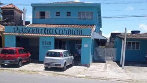 A building with the sign 'Pousada Coromoto' and the number '9810'. - Pousada Tia Carmem (Ilha Comprida)