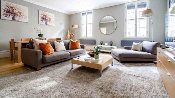 Ein modernes Wohnzimmer mit zwei Sofas, einem Couchtisch und einem Essbereich.