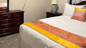 A hotel room with a bed, a dresser, a television, a lamp, and a ceiling light. - Tranquil studio in delightful Palm Coast . DBPR License number DWE2801215 (Palm Coast)