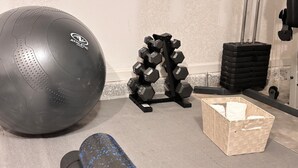 A gym with a large exercise ball, a set of dumbbells, and a foam roller. - Tranquil studio in delightful Palm Coast . DBPR License number DWE2801215 (Palm Coast)