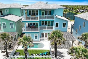 Ein mehrstöckiges Gebäude mit Balkonen, einem Swimmingpool und Palmen.