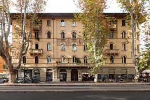 Un immeuble à plusieurs étages doté d’une entrée centrale, de balcons et d’un commerce situé au rez-de-chaussée.