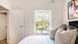 Ein Schlafzimmer mit Bett, Fenster und Tür.