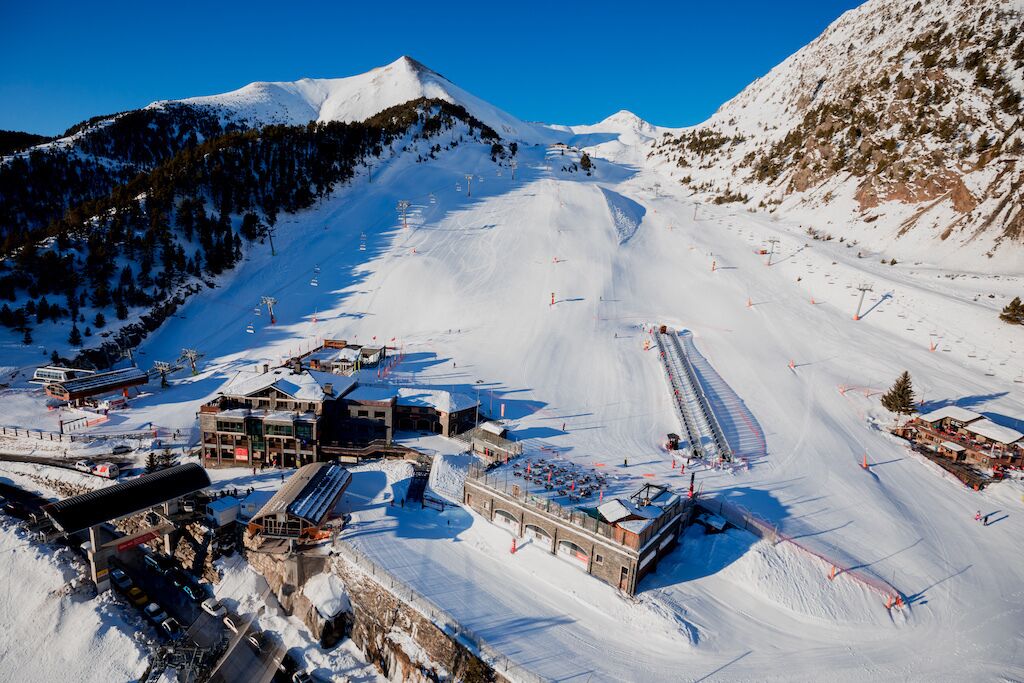 A ski resort with a chairlift, buildings, and a snow-covered mountain.