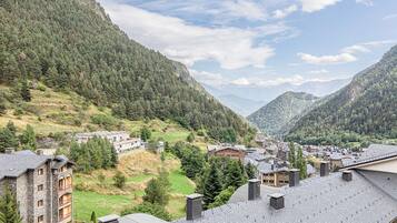 Un pueblo de montaña con arquitectura tradicional, campos en terrazas y vistas al valle.