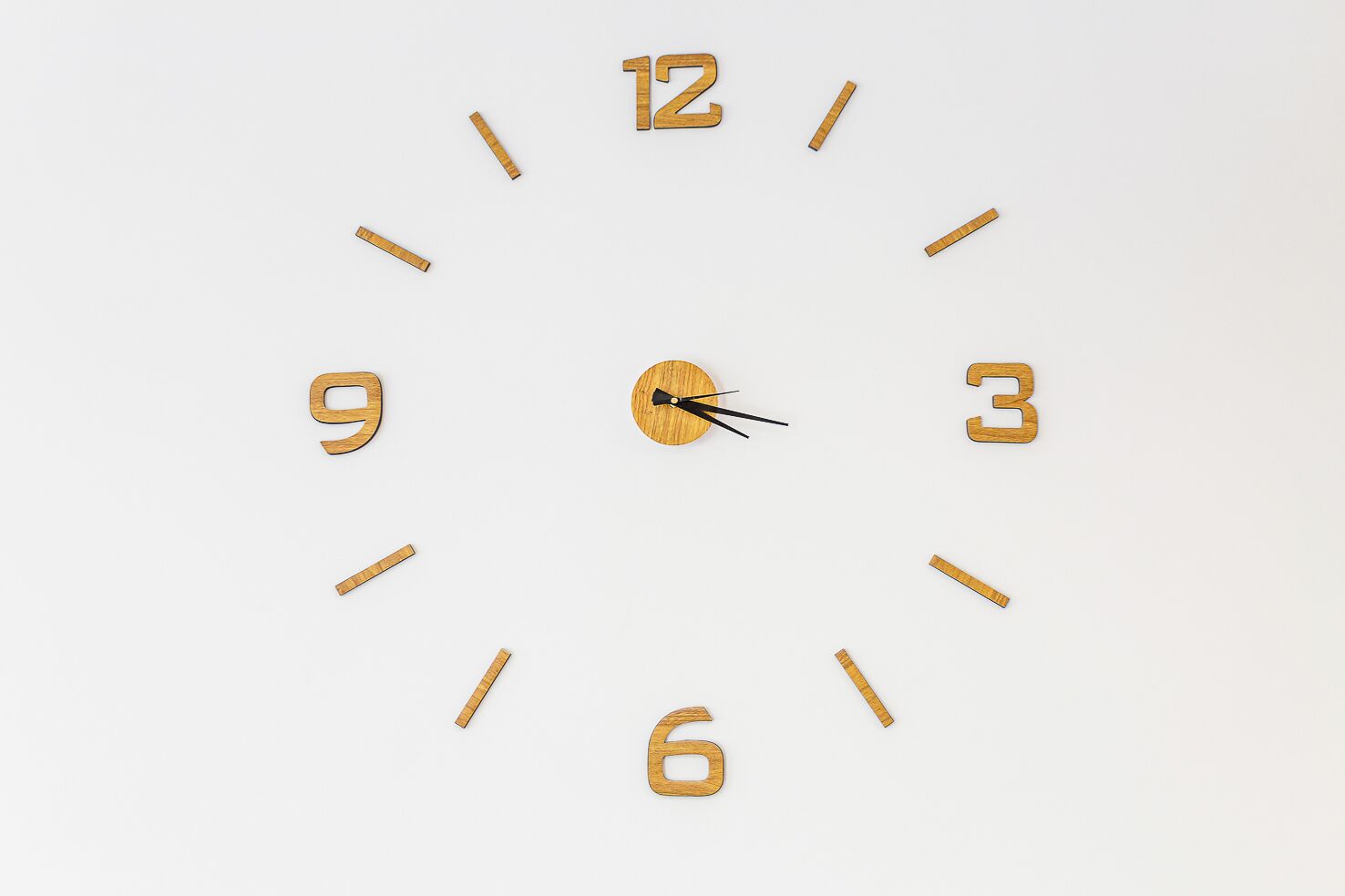 Un reloj de pared de diseño minimalista, con números y manecillas de madera.