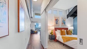 Ein modernes Hotelzimmer mit einem großen Bett, einem Nachttisch und Bildern an der Wand.