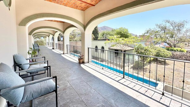 A covered outdoor area with a pool, seating, and a view of the surrounding landscape. - Studio With Salt Water Pool (Chapala)