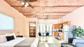 A modern hotel room with a bed, a dining area, and a kitchenette. - Studio With Salt Water Pool (Chapala)