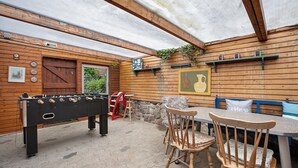 A wooden outdoor area with a foosball table, a table with chairs, and a bench. - Holiday Home 'Gerda' with Private Terrace, Private Garden and Wi-Fi (Stadum)