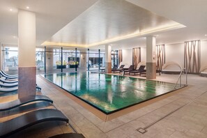 A swimming pool with lounge chairs and a sunbed area.