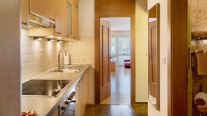 Une cuisine équipée d’une cuisinière, d’un évier et de meubles de rangement en bois.