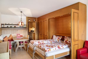 A compact room with a bed, a small table, and a chair. - Apartment 'Ilse' with Mountain View, Shared Garden and Balcony (Seefeld in Tirol)