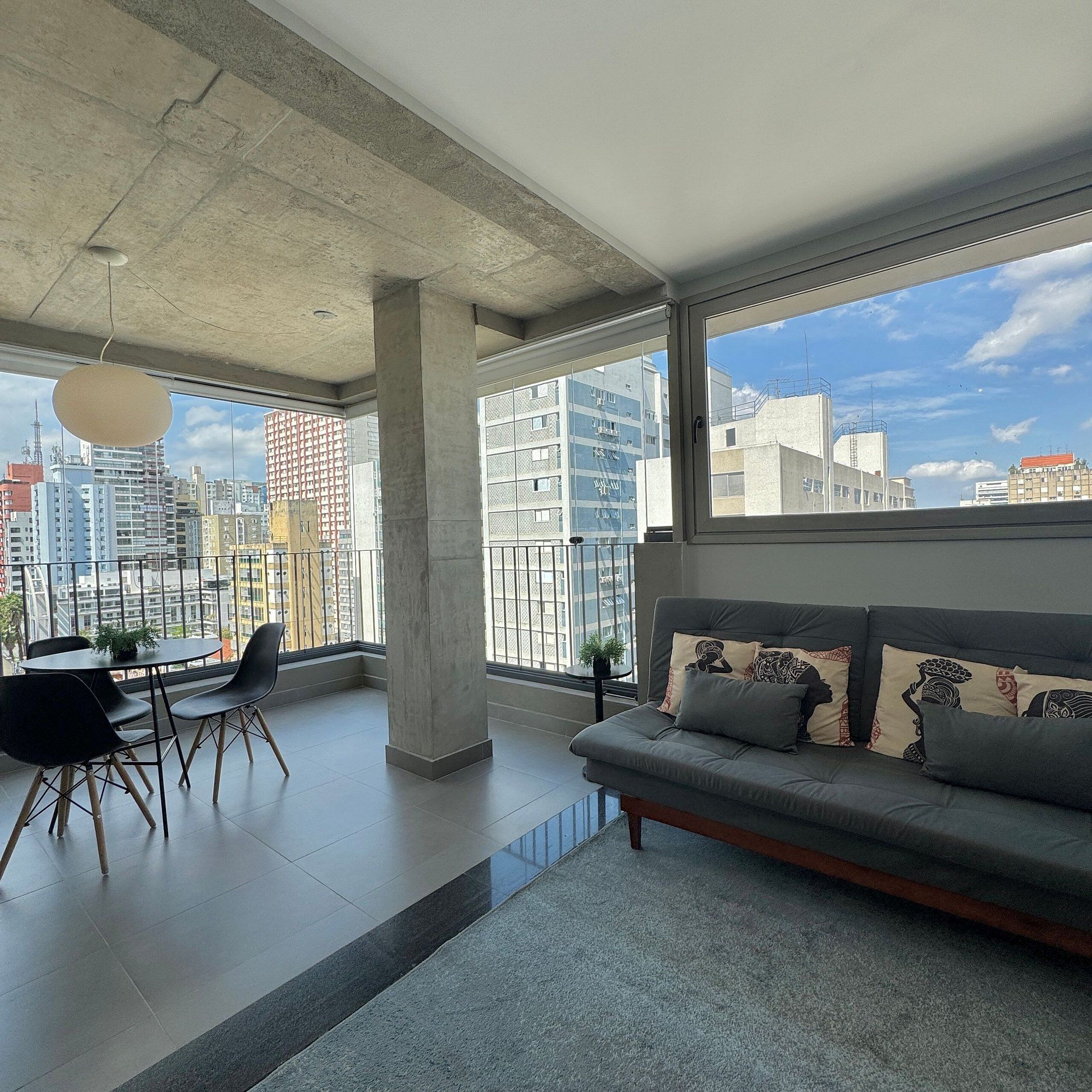 A modern living room with a sofa, chairs, and a dining table.