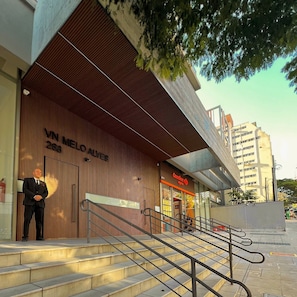 A modern building with a prominent entrance, a visible staircase, and a sign for 'Carrefour Express'. - Apartamentos Prime-Prox a Oscar Freire (São Paulo)