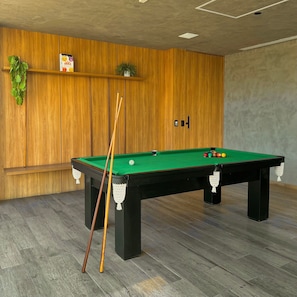 A pool table with a green felt surface, surrounded by wooden walls and a wooden floor. - Apartamentos Prime-Prox a Oscar Freire (São Paulo)