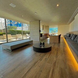 A modern living room with a sofa, a round coffee table, and a dining area with chairs. - Apartamentos Prime-Prox a Oscar Freire (São Paulo)