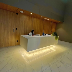A reception desk with a modern design, a wooden wall, and a tiled floor. - Apartamentos Prime-Prox a Oscar Freire (São Paulo)