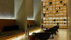 A modern lobby with a seating area, a wall with illuminated shelves, and a clean, minimalist design. - Apartamentos Prime-Prox a Oscar Freire (São Paulo)