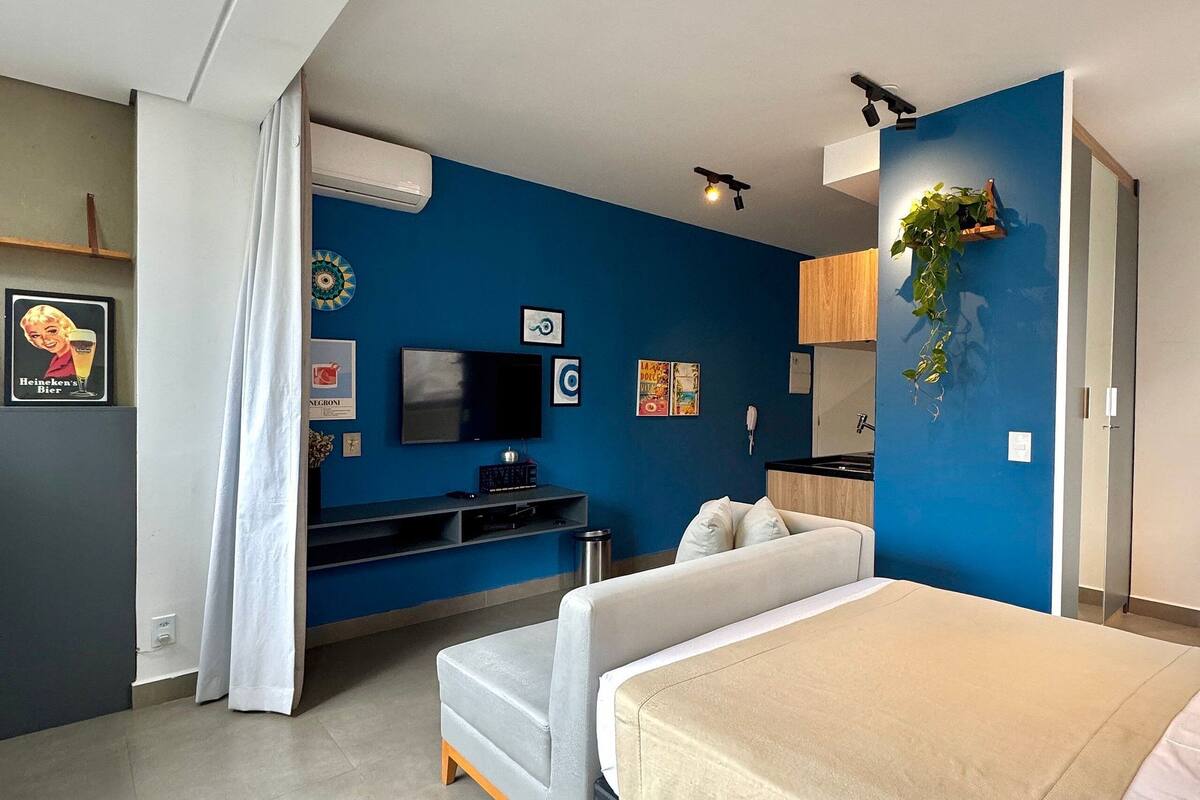 Um quarto moderno com uma cama, uma TV e uma escrivaninha.