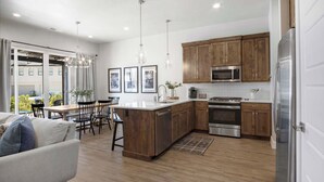 A modern kitchen with wooden cabinets, stainless steel appliances, and a central island.