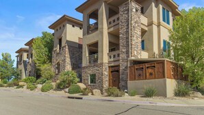 A multi-story building with a stone facade, balconies, and a covered entryway. - Desert Ocean Vibes- Resort Amenities (Hurricane)