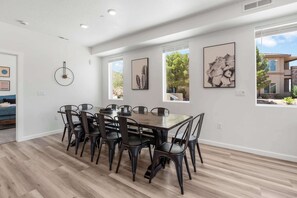 Ein Essbereich mit Holztisch, schwarzen Stühlen, weißen Wänden und Kunstwerken.