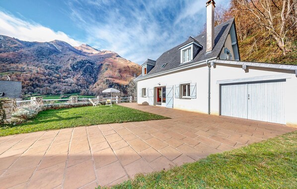 A house with a paved driveway, a garage, and a view of mountains. - 2 bedroom gorgeous home in Louvie-Soubiron (Louvie-Soubiron)