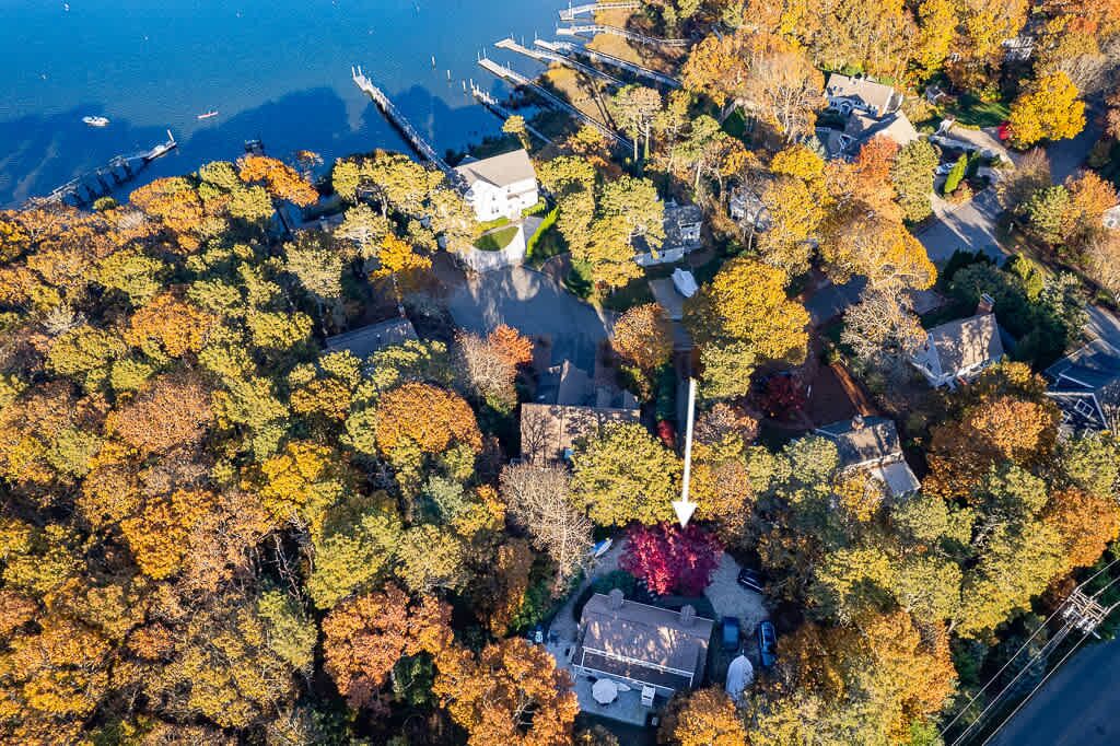 Vue aérienne d’un quartier résidentiel avec des maisons, un quai et une étendue d’eau.