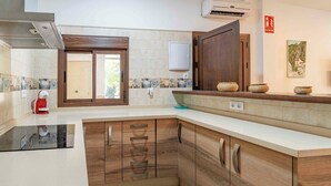 Een moderne keuken met houten kastjes, een ingebouwde kookplaat en een raam met uitzicht.