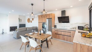 Een moderne keuken met houten kastjes, een ingebouwde oven en een roestvrijstalen koelkast.