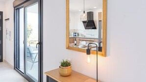 Een moderne keuken met een groot raam, een houten bankje en een potplant.
