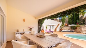 A patio area with a pool, wicker furniture, and a staircase leading to a covered outdoor area. - Quinta Felicidade, 4 bedroom holiday villa with private pool (Lagos)