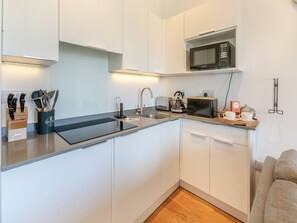 A modern kitchen with a sink, stove, microwave, and toaster. - 1 bedroom accommodation in Carbis Bay, near St Ives (Carbis Bay, near St Ives)