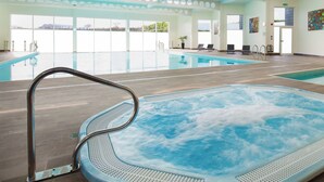 A large indoor swimming pool with a hot tub, clear windows, and a modern ceiling design. - 1 bedroom accommodation in Carbis Bay, near St Ives (Carbis Bay, near St Ives)