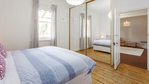 Une chambre à coucher avec un grand lit, une armoire et un miroir.