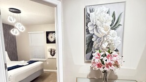 A bedroom with a bed, bedside table, and a wall-mounted artwork. - Our stunning luxury villa, complete with a heated pool, a relaxing hot tub, (Davenport)