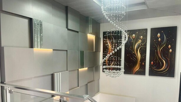 A modern staircase with glass railings and abstract wall art. - Scarlett Apartments (Monrovia)