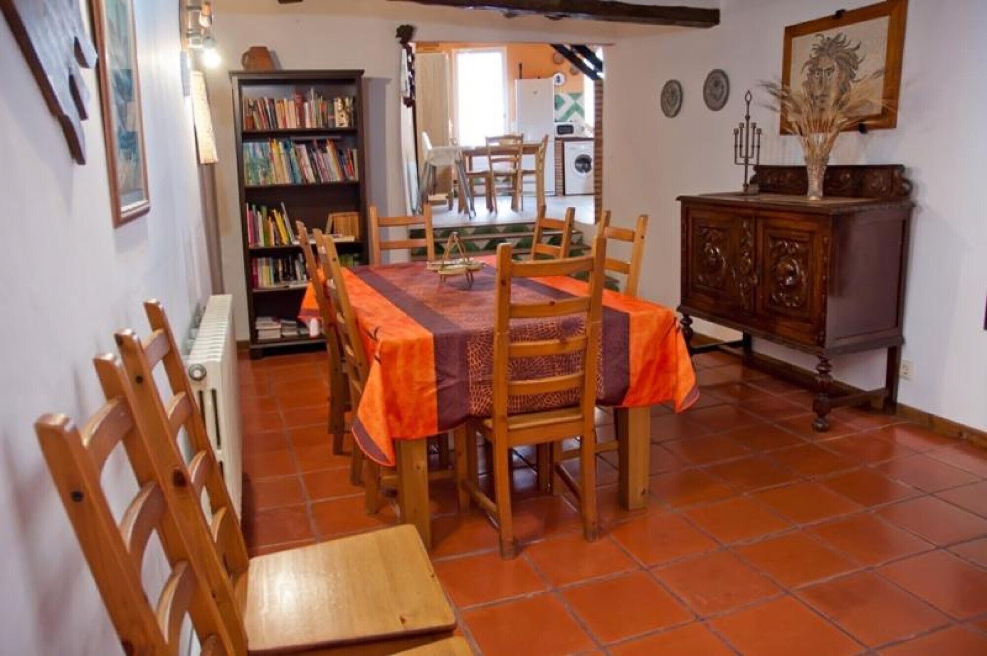 Un coin repas comprenant une table, des chaises, une bibliothèque et un meuble.