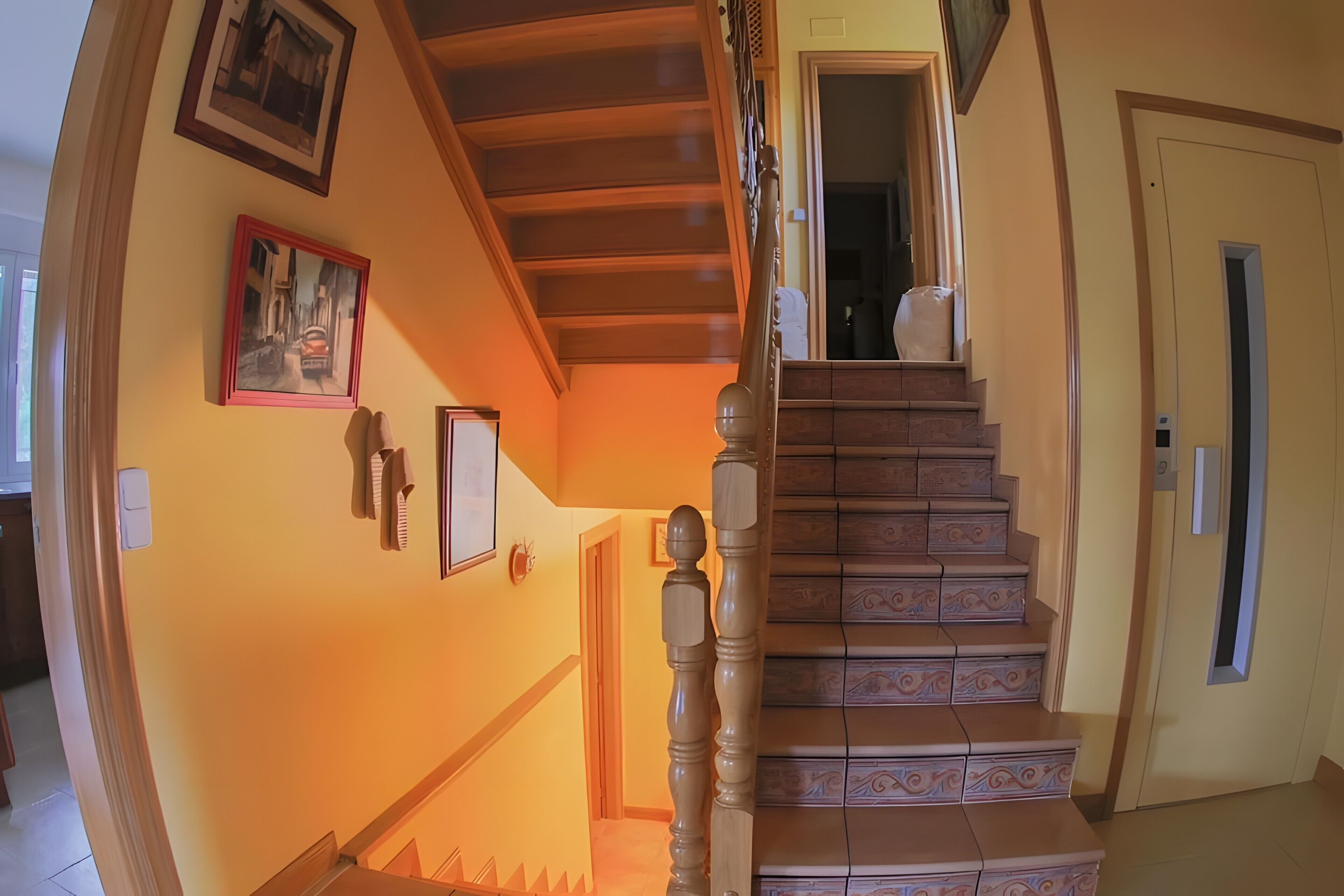 Una escalera con barandillas ornamentadas y peldaños estampados, que lleva a un piso superior.